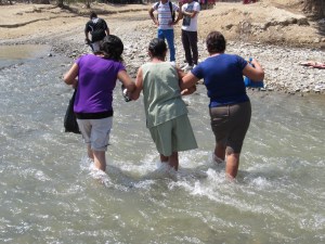Women walking across the river. There is no bridge.